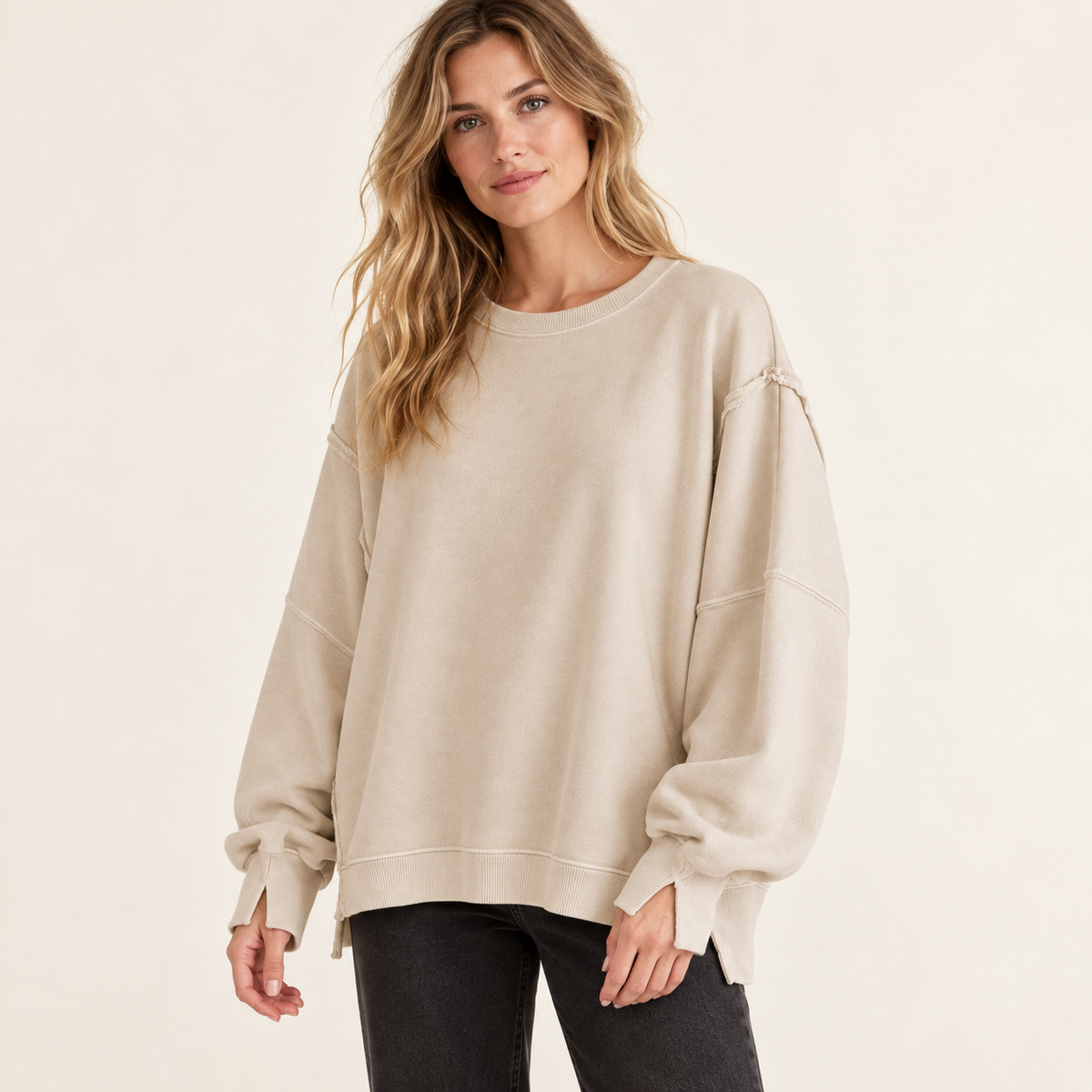 Beige women's oversized split-hem sweatshirt, front view on a synthetic adult model