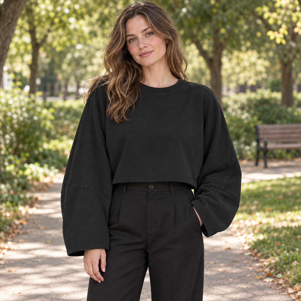 Black women's wide-sleeve cropped sweatshirt on a park path on a synthetic adult model