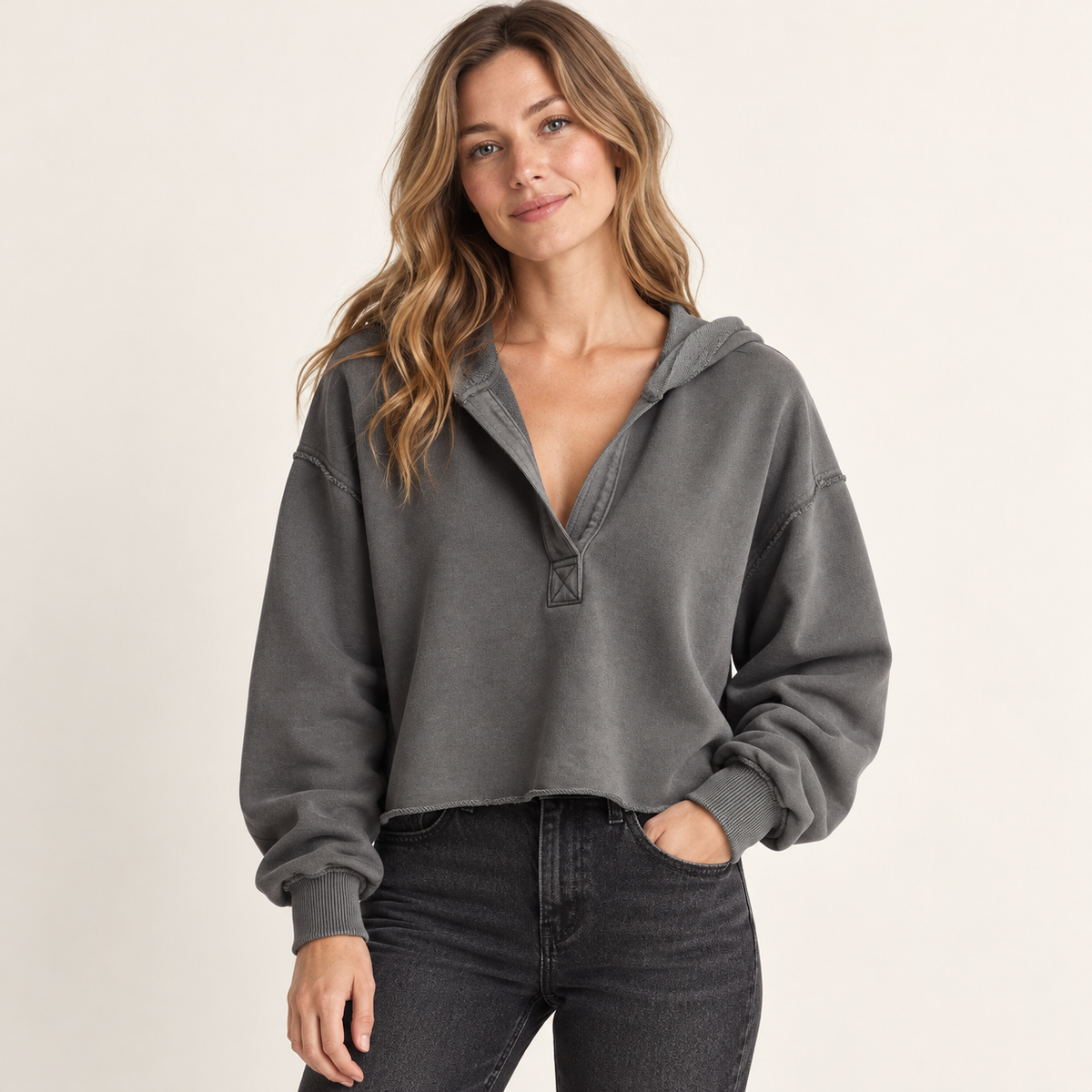 Gray women's cropped V-neck hoodie, front view on a synthetic adult model