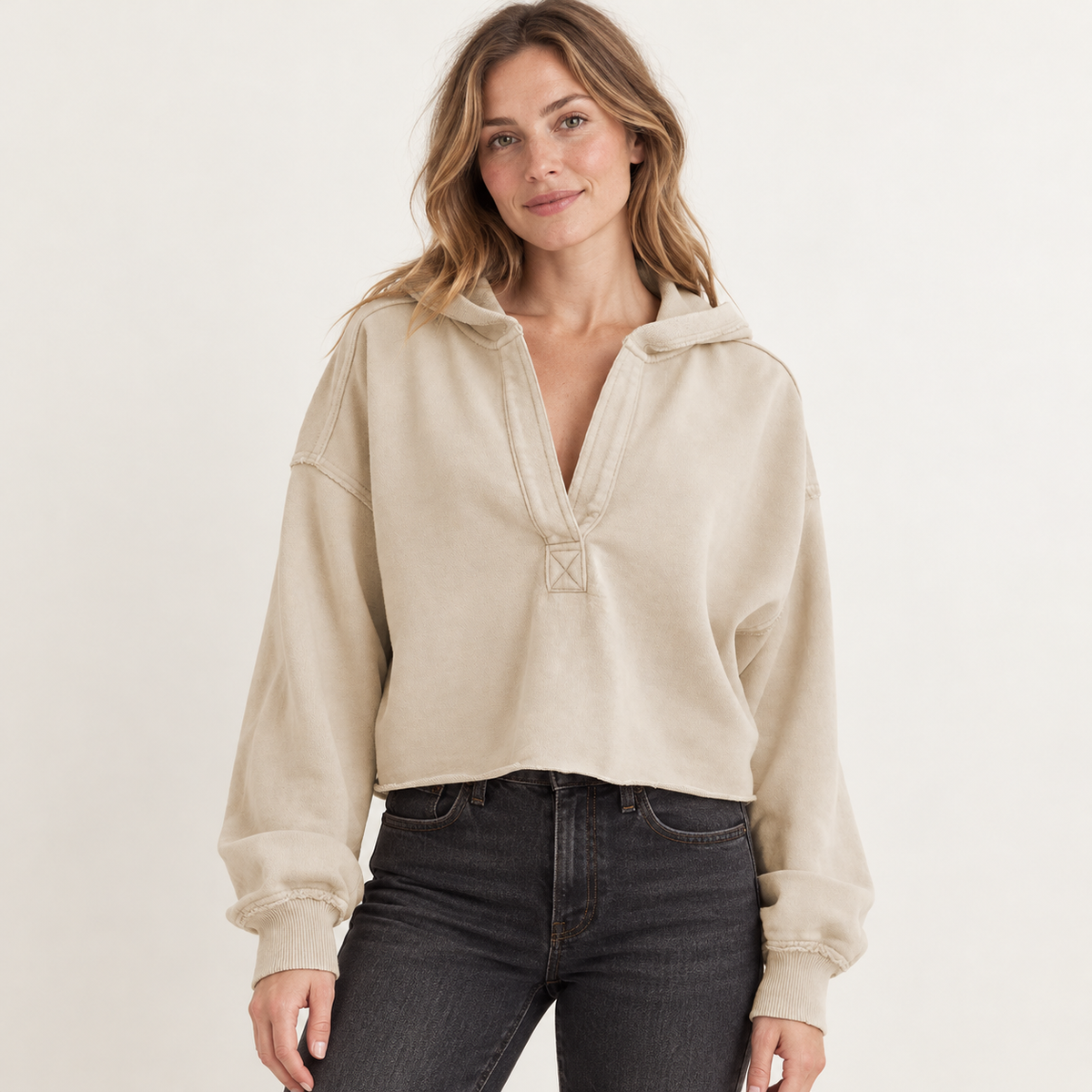 Beige women's cropped V-neck hoodie, front view on a synthetic adult model