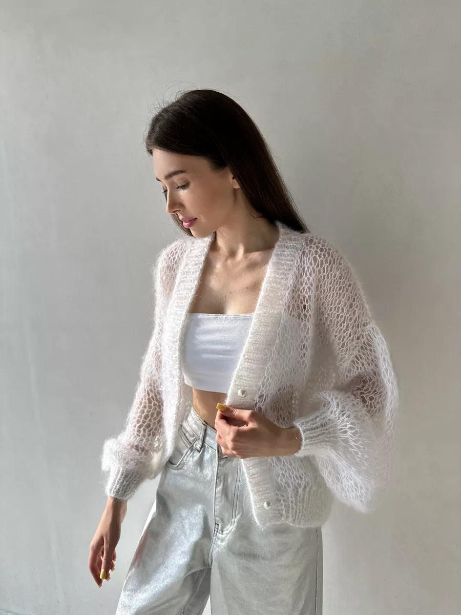 Original product photo: white open-knit cardigan worn open over a camisole, showing its sheer knit and ribbed cuffs