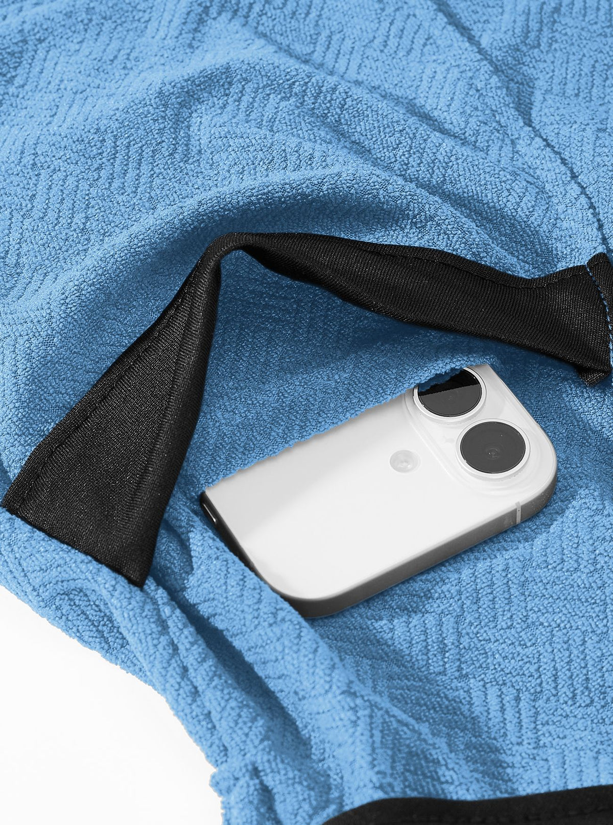 Blue terry bathrobe pocket detail with a phone showing pocket placement