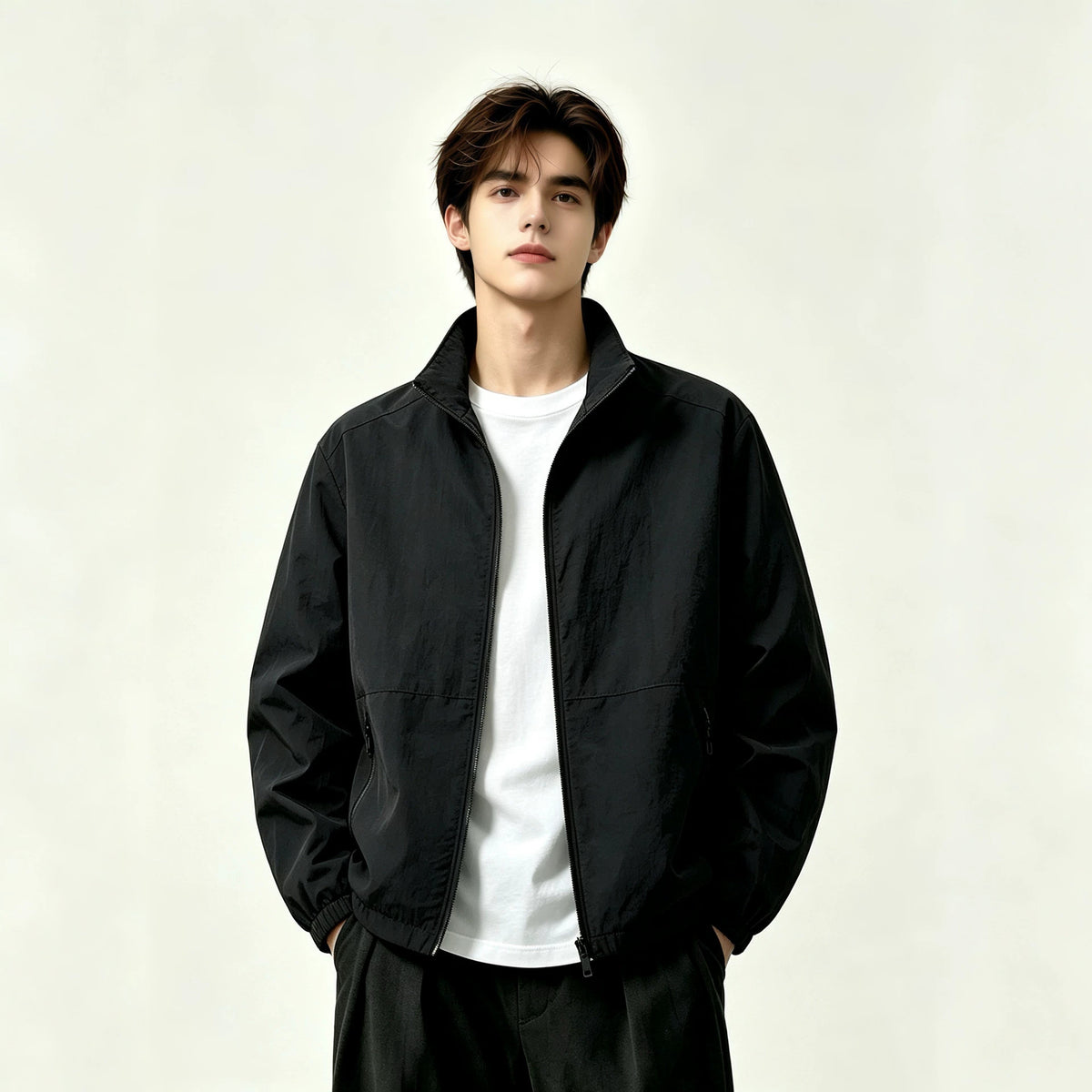 Adult model wearing the AZUKI black stand-collar zip jacket, front view